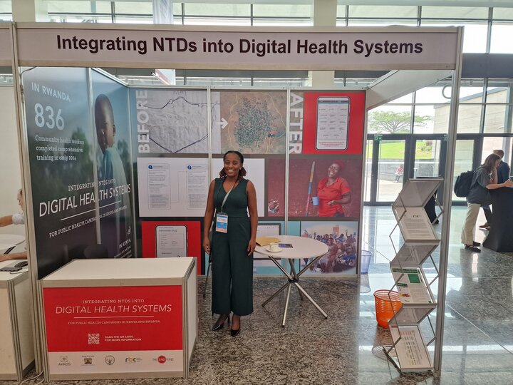 Florence Wakesho, MoH Kenya, standing in front of a display on Integrating NTDs into Digital Health Systems.
