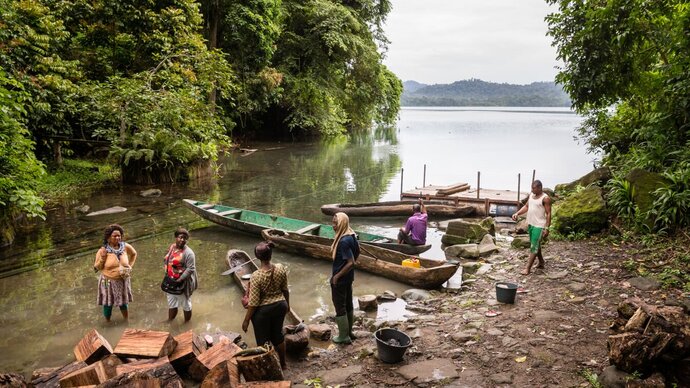 People standing in a shallow lake around a boat. Copyright Merck KGaA