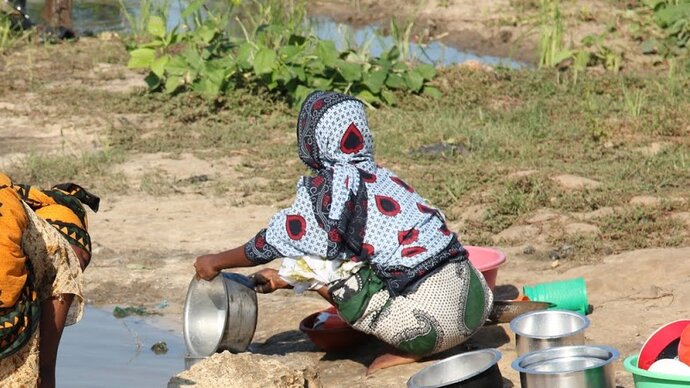 Woman washing pots in local water body - Zanzibar transmission site. Image credit David Rollinson