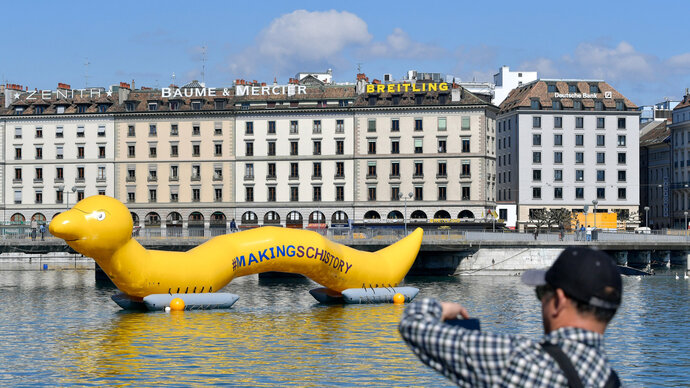 Photo of an inflatable yellow worm floating on Lake Geneva, part of the Macking Schistory Campaign