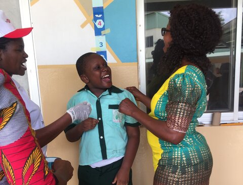 Older boy feels supported by trusted adults during deworming MDA at school for children with disabilities in Bwari Area Council, FCT, Nigeria © CBM 2019