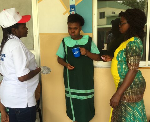 Older girl is concerned about taking deworming tablet at school for children with disabilities in Bwari Area Council, FCT, Nigeria © CBM 2019