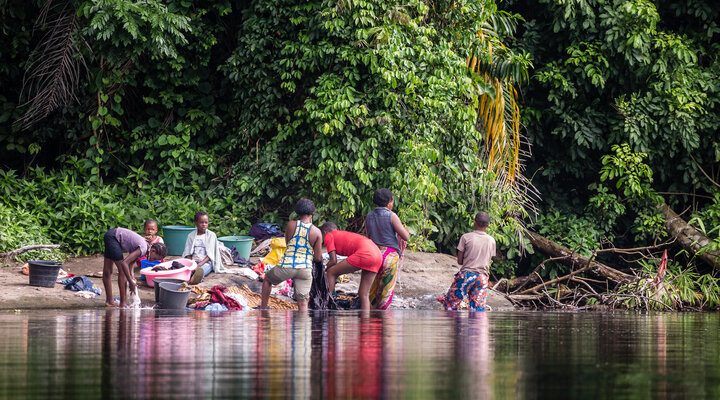 Women washing clothes by the bank of a river